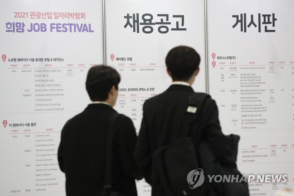 Jobseekers look at employment information at a job fair held at aT Center in southern Seoul, in the Nov. 16, 2021, file photo. (Yonhap)