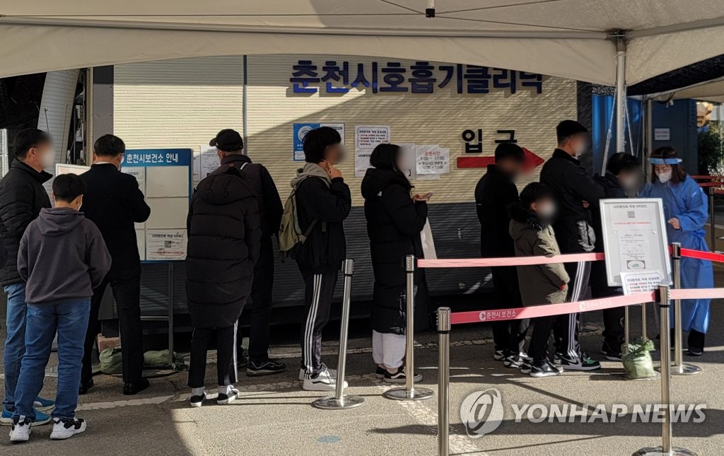 Las personas espera en fila, el 27 de noviembre de 2021, para hacerse la prueba del COVID-19 en una clínica provisional de exámenes de coronavirus en Chuncheon, en la provincia de Gangwon.