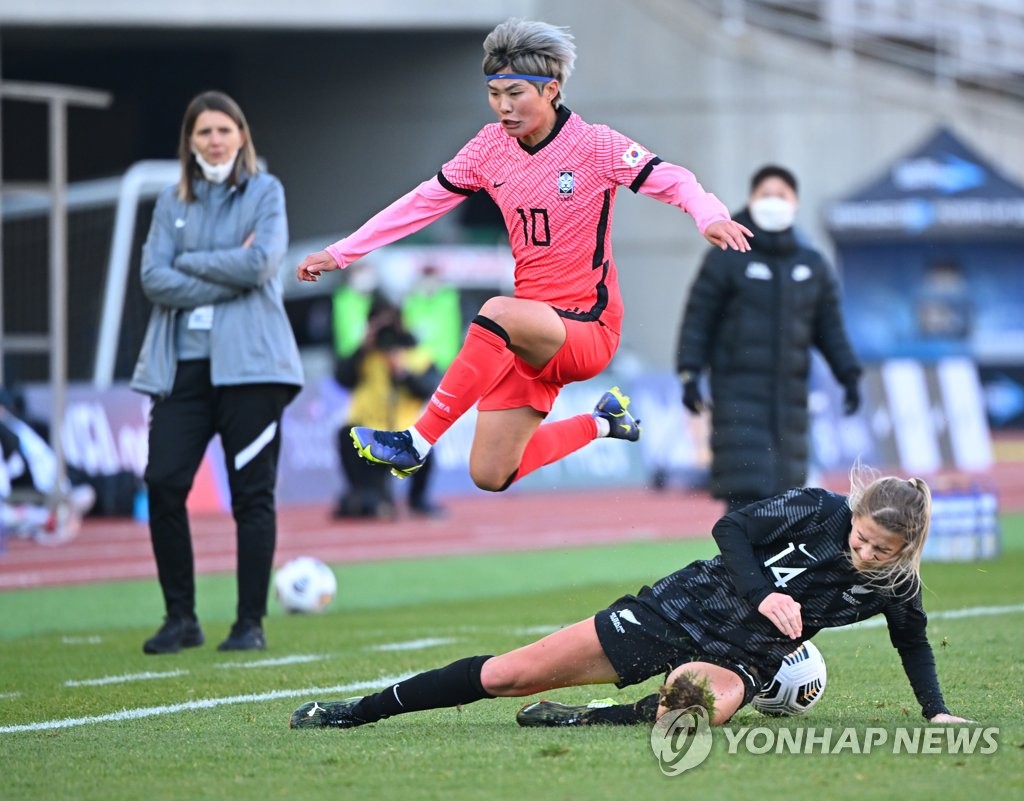 Ji So-yun of South Korea (L) jumps over Katie Bowen of New Zealand during the teams' friendly football match at Goyang Stadium in Goyang, Gyeonggi Province, on Nov. 27, 2021. (Yonhap)