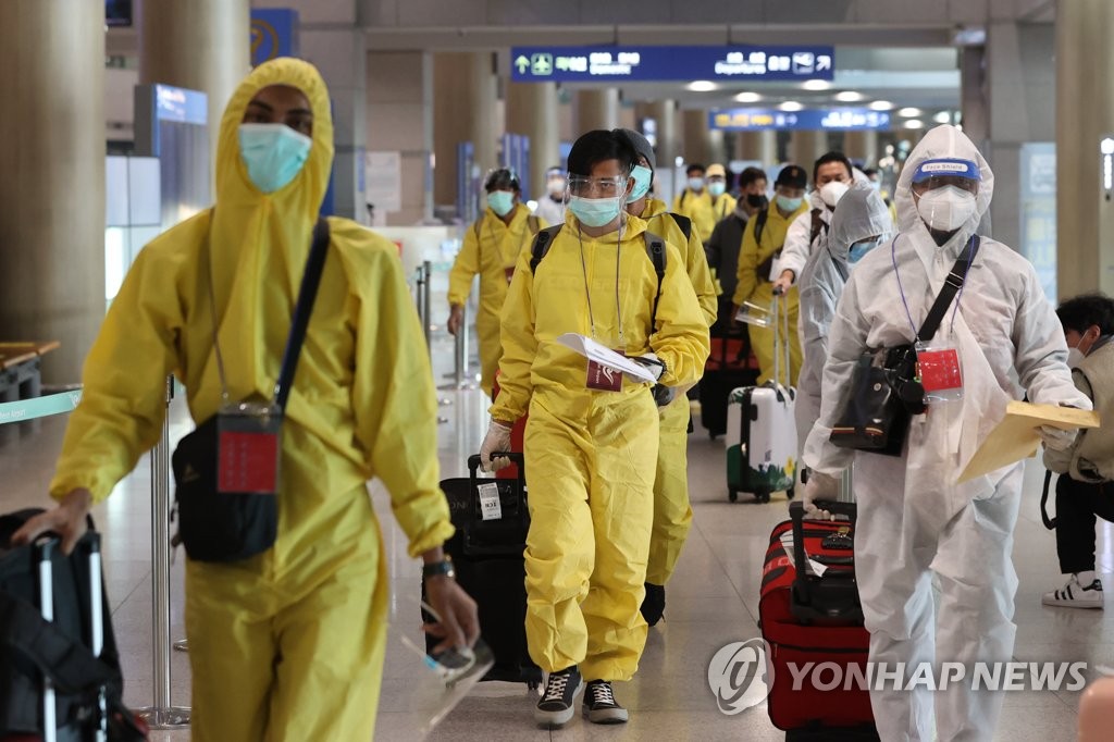 Des passagers portant des équipements de protection arrivent à l'aéroport international d'Incheon, à l'ouest de Séoul, le 29 novembre 2021. (Yonhap)