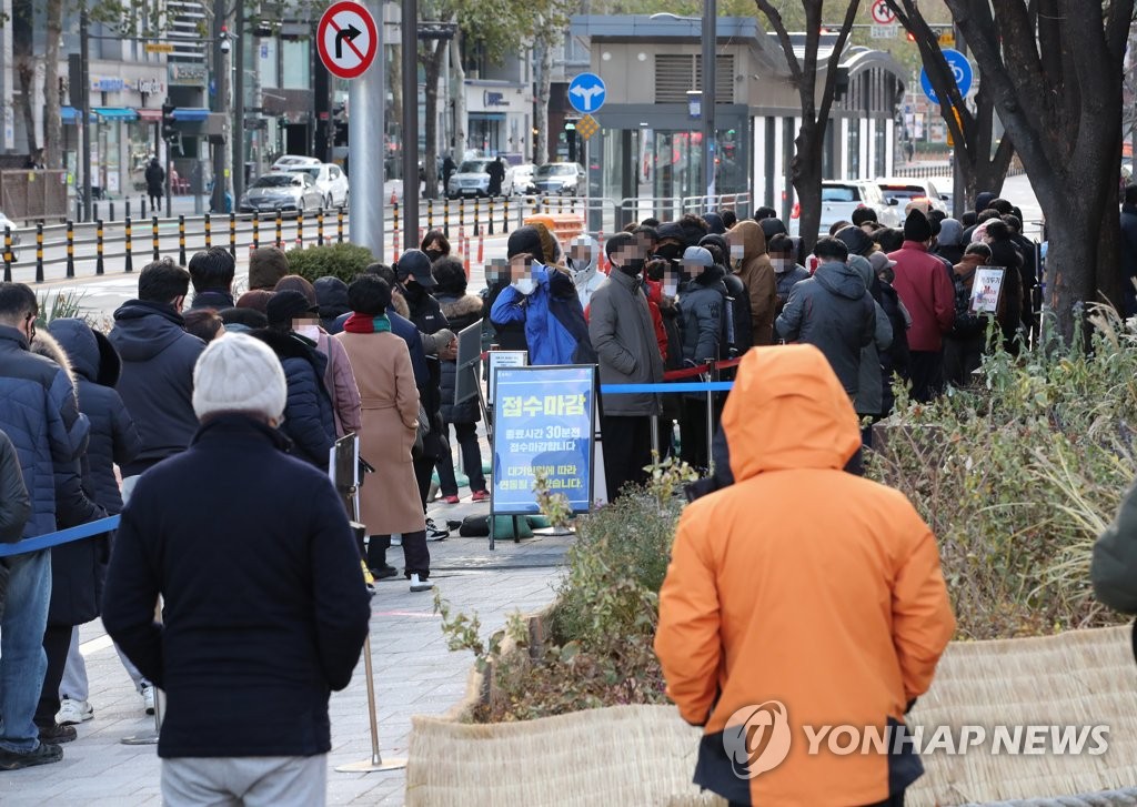 Las personas esperan en fila, el 4 de diciembre de 2021, para realizar la prueba del coronavirus en un centro de salud pública en el distrito de Songpa, en el sudeste de Seúl.