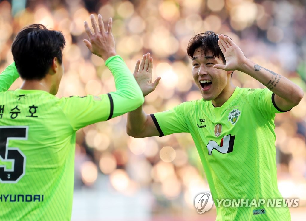 Song Min-kyu of Jeonbuk Hyundai Motors (R) celebrates his goal against Jeju United with teammates Paik Seung-ho during the clubs' K League 1 match at Jeonju World Cup Stadium in Jeonju, some 240 kilometers south of Seoul, on Dec. 5, 2021. (Yonhap)