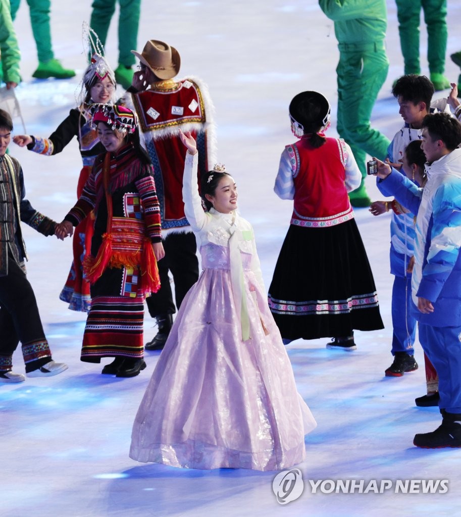 A Chinese performer dressed in the traditional Korean attire of hanbok waves during the opening ceremony for the 2022 Beijing Winter Olympics at the National Stadium in Beijing on Feb. 4, 2022. (Yonhap)