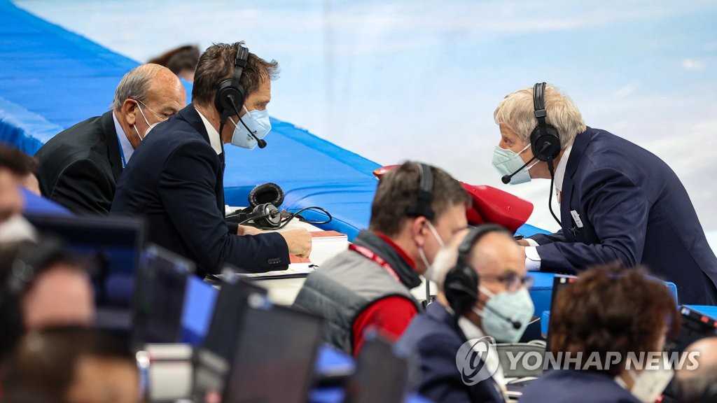 Referee Peter Worth (R) speaks with a video referee following a short track speed skating race during the Beijing Winter Olympics at Capital Indoor Stadium in Beijing on Feb. 7, 2022. (Yonhap)