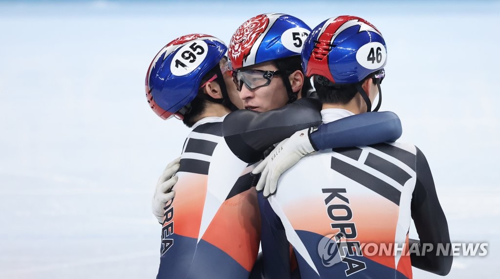 Le patineur sud-coréen Hwang Dae-heon (au centre) se réjouit avec ses homologues Lee June-seo et Park Jang-hyuk après avoir remporté la médaille d'or à l'épreuve du 1.500m masculin de patinage de vitesse sur piste courte, aux Jeux olympiques d'hiver de Pékin 2022, au Palais omnisports de la capitale, le mercredi 9 février 2022.