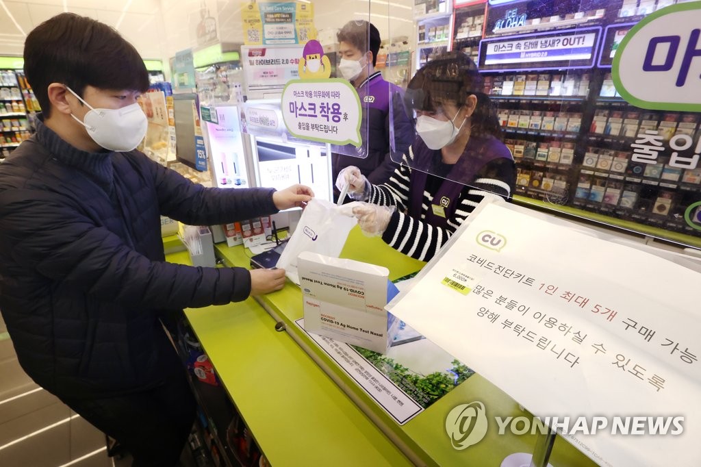 ソウル市内のＣＵの店舗で、小分け販売されている検査キットを購入する客＝１５日、ソウル（聯合ニュース）