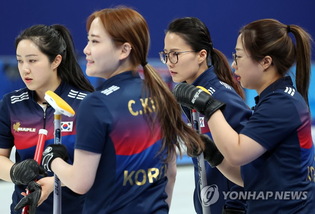 Les curleuses sud-coréennes Kim Kyeong-ae, Kim Cho-hi, Kim Eun-jung et Kim Seon-yeong (de g. à dr.) lors d'un match de curling féminin du tournoi toutes rondes contre la Suède aux Jeux olympiques d'hiver de Pékin 2022 au Centre aquatique national de Pékin, le jeudi 17 février 2022.