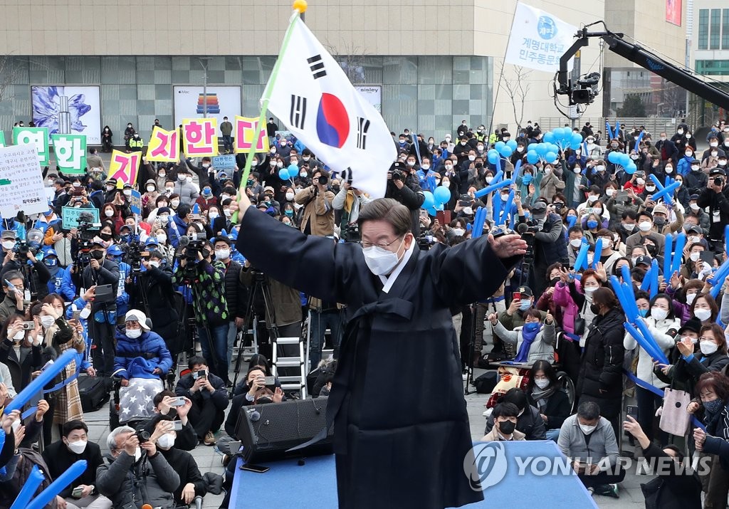 Lee Jae-myung, the presidential candidate of the ruling Democratic Party, waves the national flag during a campaign rally in the southeastern city of Daegu on Feb. 28, 2022. (Pool photo) (Yonhap)