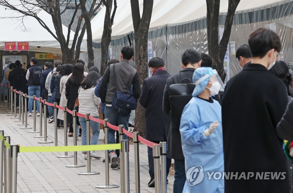 ソウル広場の新型コロナ臨時検査所で、市民が長い列をつくり検査の順番を待っている＝１１日、ソウル（聯合ニュース）