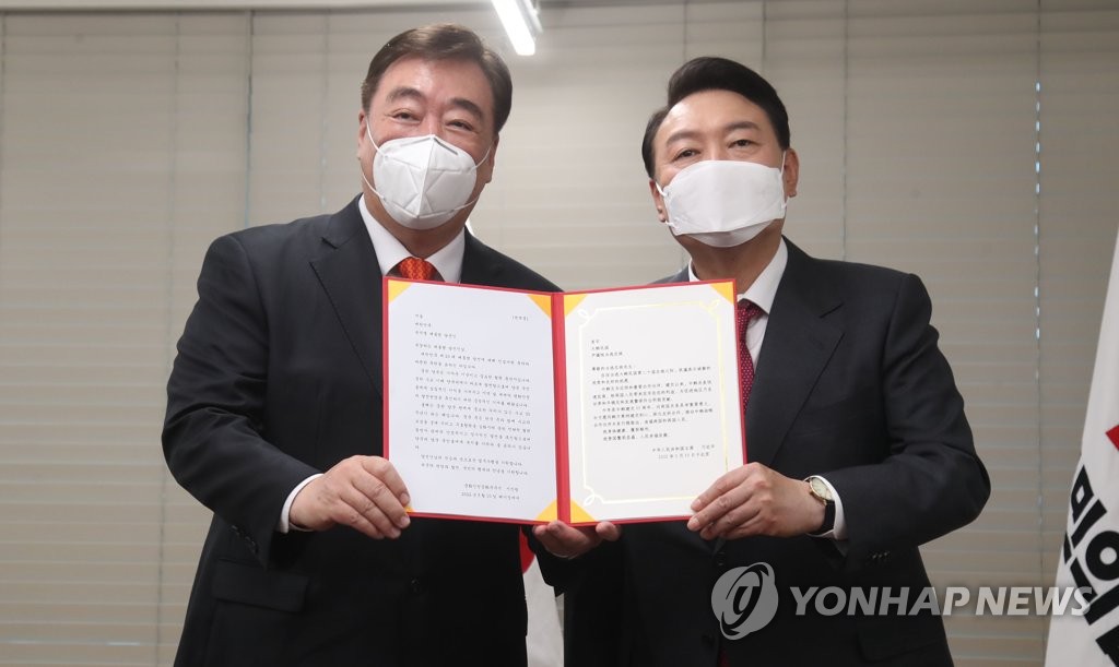 President-elect Yoon Suk-yeol (R) poses for a photo with Chinese Ambassador to South Korea Xing Haiming during their meeting at the headquarters of the main opposition People Power Party in Seoul on March 11, 2022, after receiving a congratulatory letter on Yoon's election as South Korea's next leader from Chinese President Xi Jinping. (Pool photo) (Yonhap)