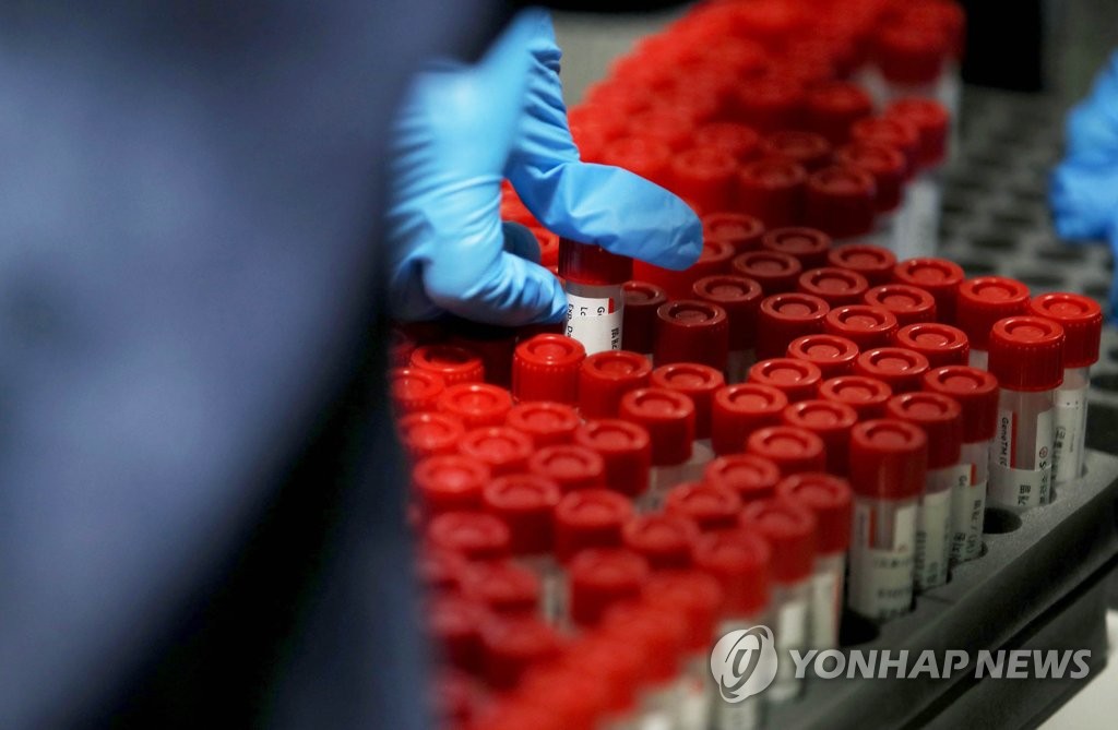 Medical personnel check COVID-19 samples collected from potential patients for diagnostic tests at a testing station in the southwestern city of Gwangju, about 300 kilometers away from Seoul, in this photo provided by the Buk Ward in the city on March 16, 2022. (PHOTO NOT FOR SALE) (Yonhap) 