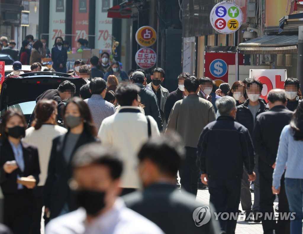 This photo, taken April 8, 2022, shows a street crowded with people wearing masks in Myeongdong, which used to be a popular tourist hotspot before the COVID-19 pandemic outbreak two years ago. The government plans to announce a new "post-omicron" scheme later this week aimed at lifting most of the virus restrictions and social distancing as the country, with nearly 30 percent of the population having been infected with COVID-19, prepares to return to normalcy while embracing the virus as an endemic disease. (Yonhap)