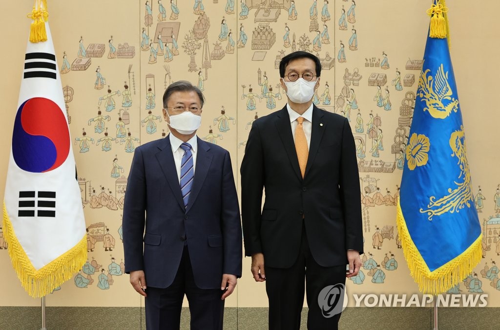 El presidente surcoreano Moon Jae-in (izda.) posa para una foto con Rhee Chang-yong, el nuevo gobernador del Banco de Corea, tras concederle una carta de nombramiento, el 21 de abril de 2022, en la oficina presidencial, Cheong Wa Dae, en Seúl.