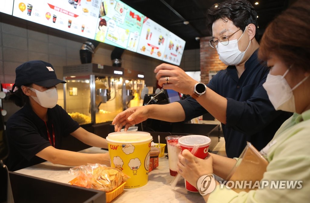 In this file photo taken April 25, 2022, moviegoers buy a bucket of popcorn at a movie theater in Jeonju, south of Seoul. (Yonhap)