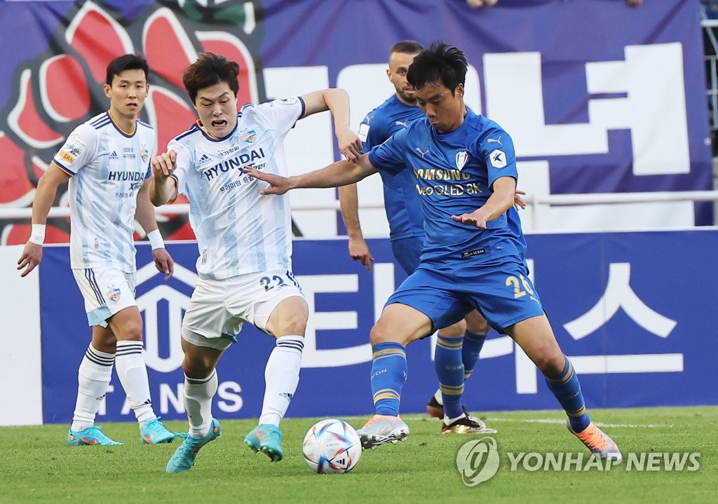 In this file photo from May 5, 2022, Yeom Ki-hun of Suwon Samsung Bluewings (R) battles Koh Myong-jin of Ulsan Hyundai FC for the ball during the clubs' K League 1 match at Suwon World Cup Stadium in Suwon, some 35 kilometers south of Seoul. (Yonhap)