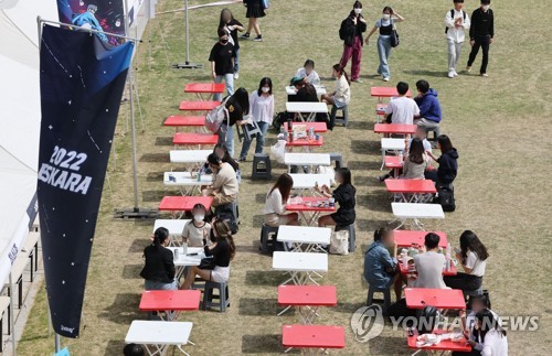 成均館大で開催された学園祭で食事をする学生。韓国では２日から屋外でのマスク着用義務が解除されている＝（聯合ニュース）