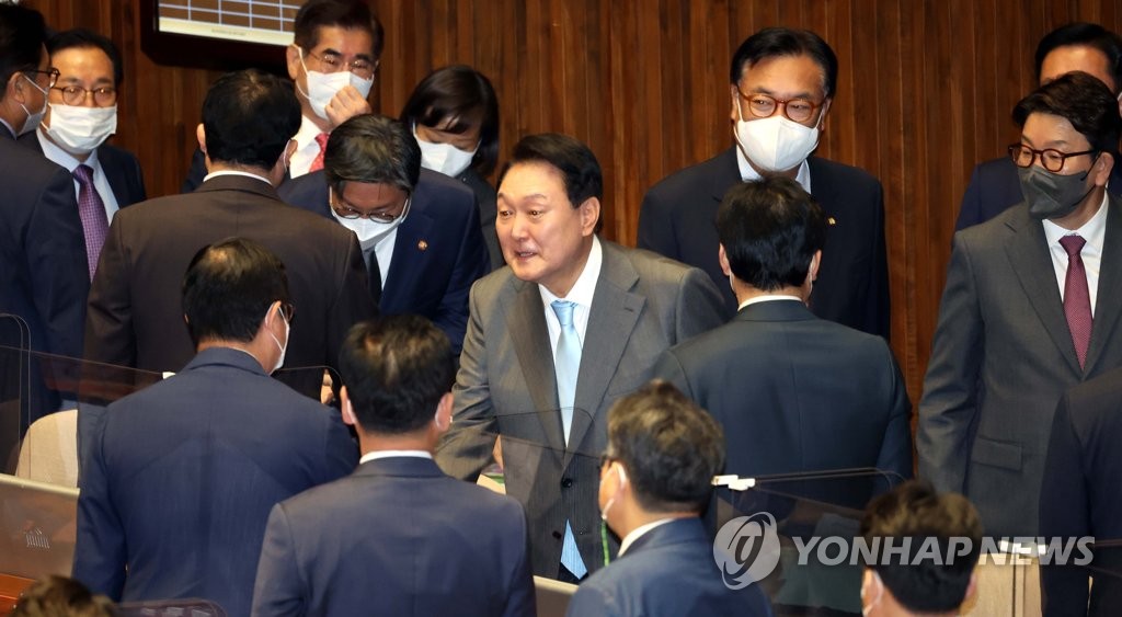 Le président Yoon Suk-yeol serre la main de députés le lundi 16 mai 2022 après avoir prononcé lors d'une séance plénière de l'Assemblée nationale son premier discours-programme sur le budget supplémentaire de 59.400 milliards de wons (46,3 milliards de dollars) proposé par le gouvernement pour aider les petits commerçants frappés par la pandémie de nouveau coronavirus (Covid-19). (Pool photo)