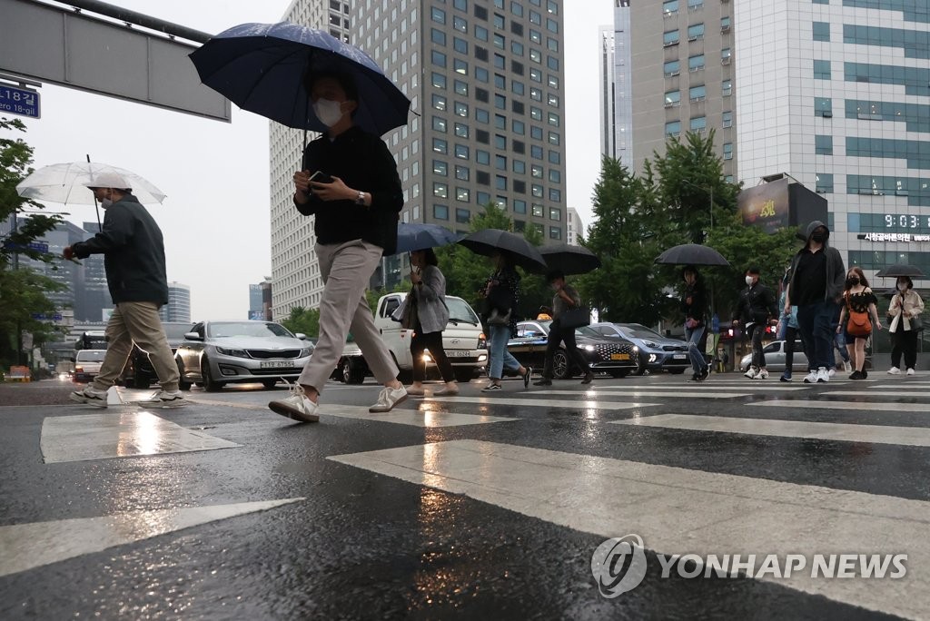 서울 광화문역 인근에서 시민들이 우산을 쓰고 횡단보도를 건너고 있다. [연합뉴스 자료사진]