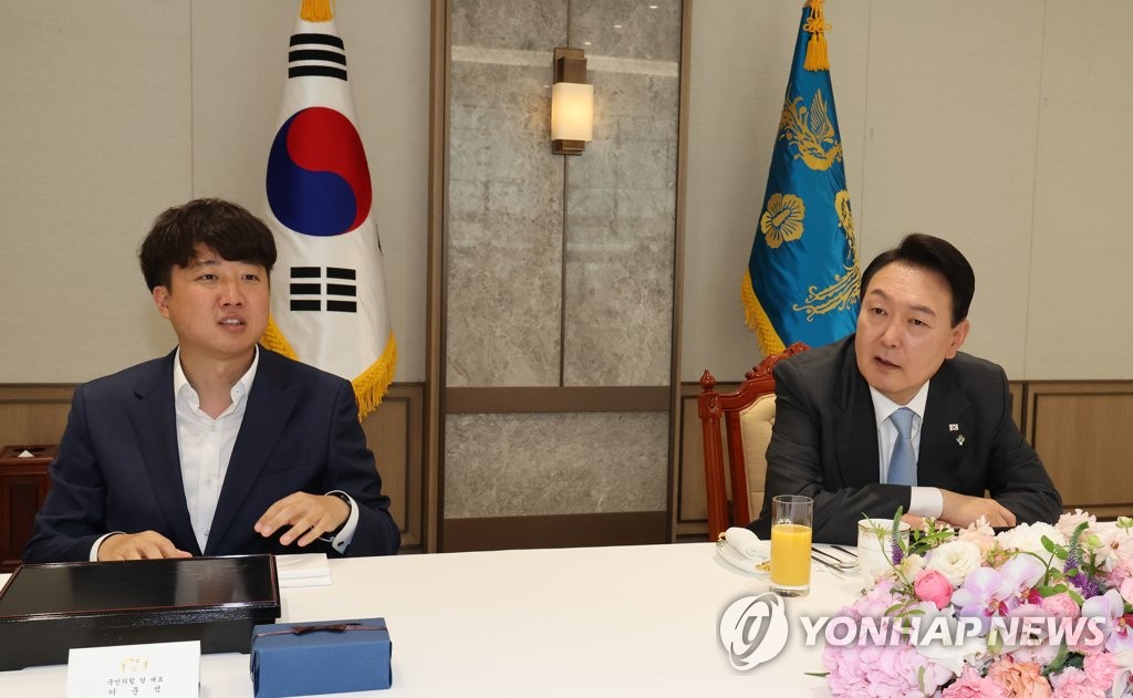 El presidente surcoreano, Yoon Suk-yeol (dcha.), habla con el jefe del gobernante Partido del Poder del Pueblo (PPP), Lee Jun-seok, el 10 de junio de 2022, durante un almuerzo de trabajo, en la oficina presidencial, en Seúl.