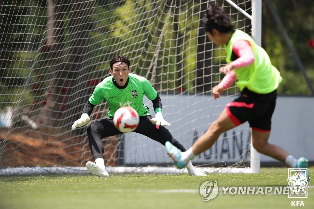 South Korean goalkeeper Kim Seung-gyu (L) tries to make a stop during an opening training session for the men's national football team at the National Football Center in Paju, Gyeonggi Province, on June 11, 2022, in this photo provided by the Korea Football Association. (PHOTO NOT FOR SALE) (Yonhap)