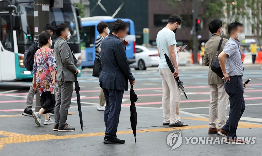 서울 종로구 광화문 네거리에서 시민들이 우산을 들고 있다. [연합뉴스 자료사진]