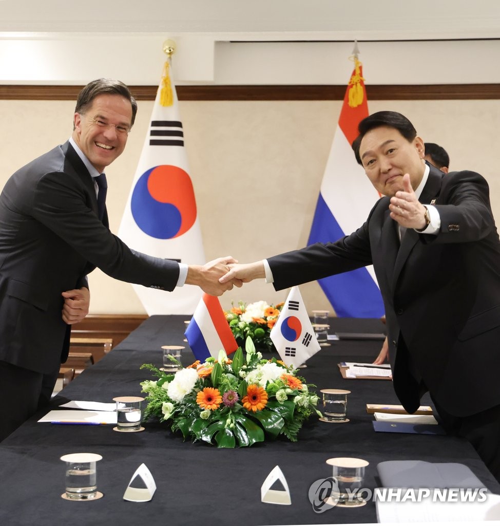 El presidente surcoreano, Yoon Suk-yeol (dcha.), posa ante la cámara, el 29 de junio de 2022, con el primer ministro neerlandés, Mark Rutte, durante su re de la Organización del Tratado del Atlántico Norte, en Madrid.