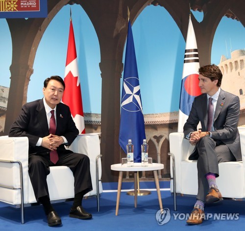 El presidente surcoreano, Yoon Suk-yeol (izda.), mantiene conversaciones con el primer ministro canadiense, Justin Trudeau, el 30 de junio de 2022 (hora local), en el Centro de Convenciones de IFEMA, en Madrid (España), al margen de una cumbre de la Organización del Tratado del Atlántico Norte. 