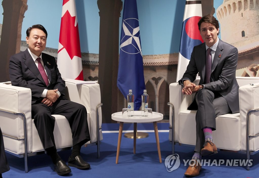 La foto de archivo muestra al presidente surcoreano, Yoon Suk-yeol (izda.), manteniendo conversaciones con el primer ministro canadiense, Justin Trudeau, el 30 de junio de 2022 (hora local), en el Centro de Convenciones de IFEMA, en Madrid, al margen de una cumbre de la Organización del Tratado del Atlántico Norte (OTAN).
