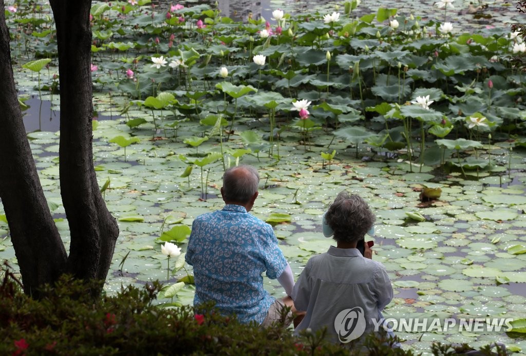 A senior couple sit by a lake in Gwangju, about 270 kilometers south of Seoul, in the July 4, 2022, file photo. (Yonhap)