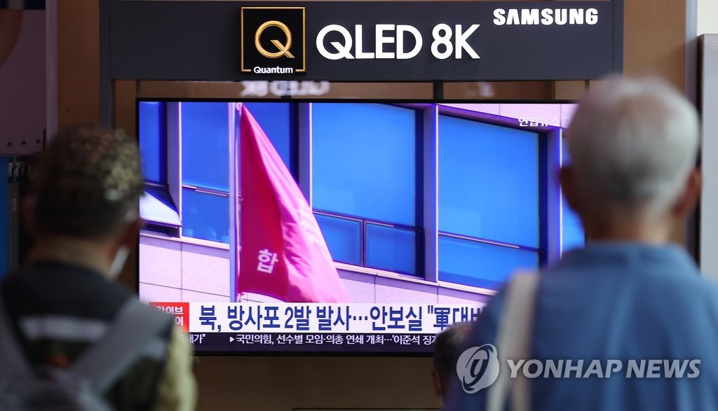 Citizens watch a television news report on North Korea's firing of suspected artillery shots at Seoul Station in the capital city on July 11, 2022. (Yonhap) 