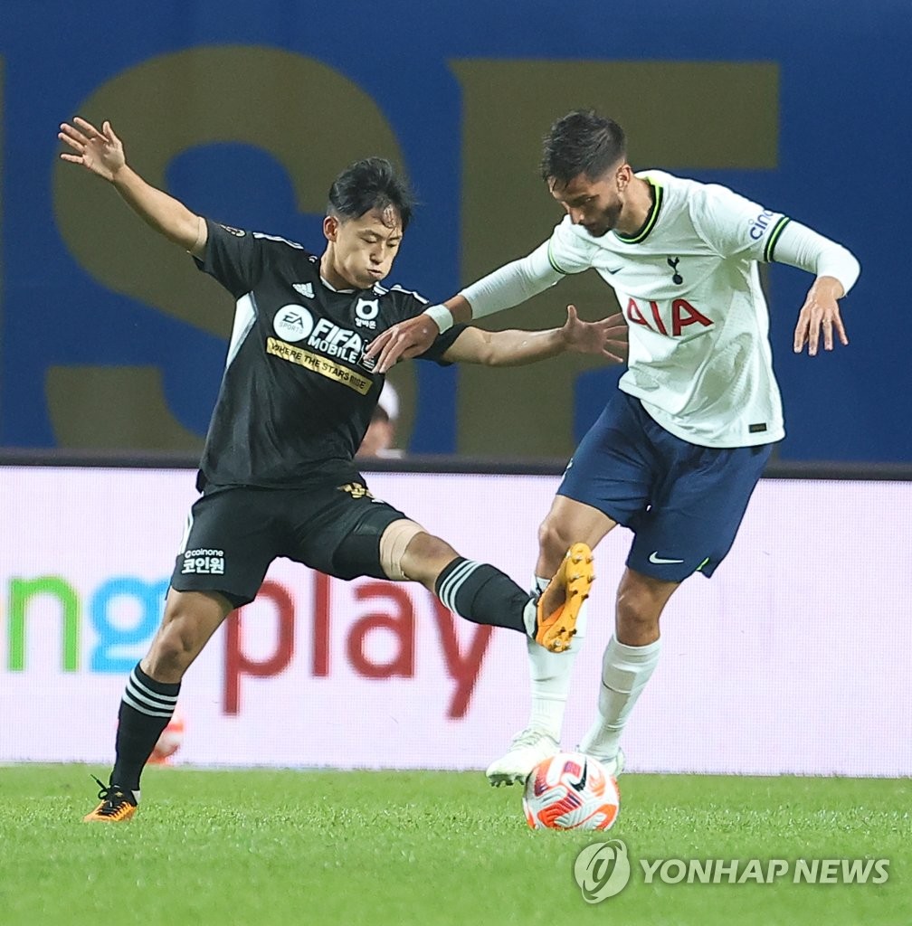 In this file photo from July 13, 2022, Lee Seung-woo of Team K League (L) battles Rodrigo Bentancur of Tottenham Hotspur during their exhibition match at Seoul World Cup Stadium in Seoul. (Yonhap)