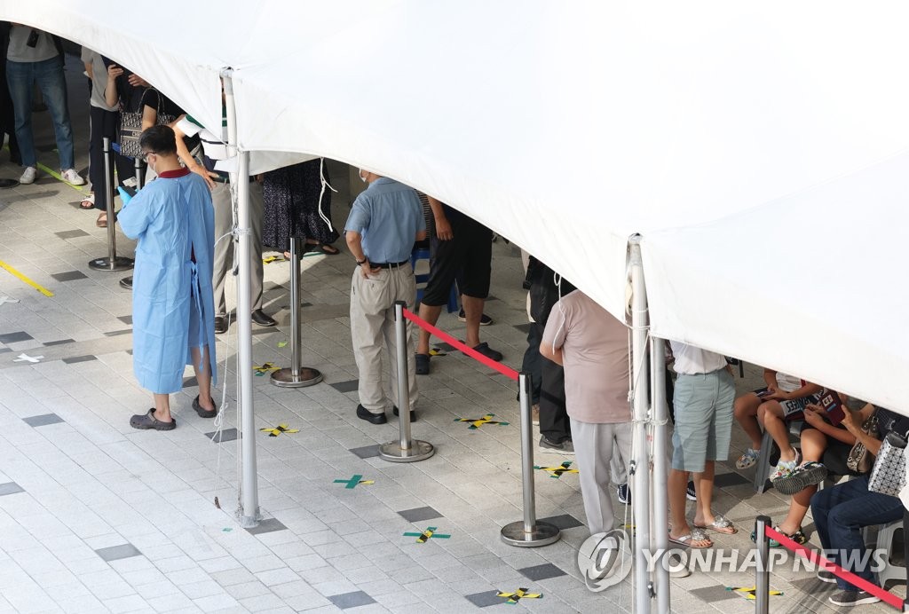ソウル市麻浦区の保健所内に設置されている新型コロナウイルス検査所で、市民が列をつくり検査の順番を待っている＝２９日、ソウル（聯合ニュース）