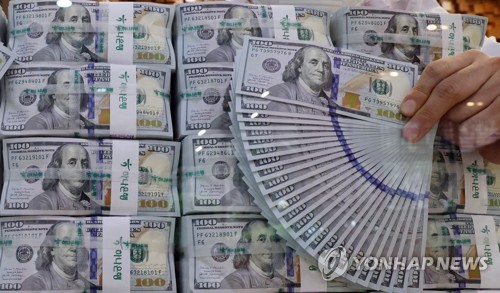 This undated file photo shows stacks of U.S. dollars. (Yonhap)