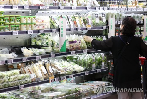A shopper selects groceries at a discount store in Seoul amid high inflation on Aug. 29, 2022. (Yonhap)