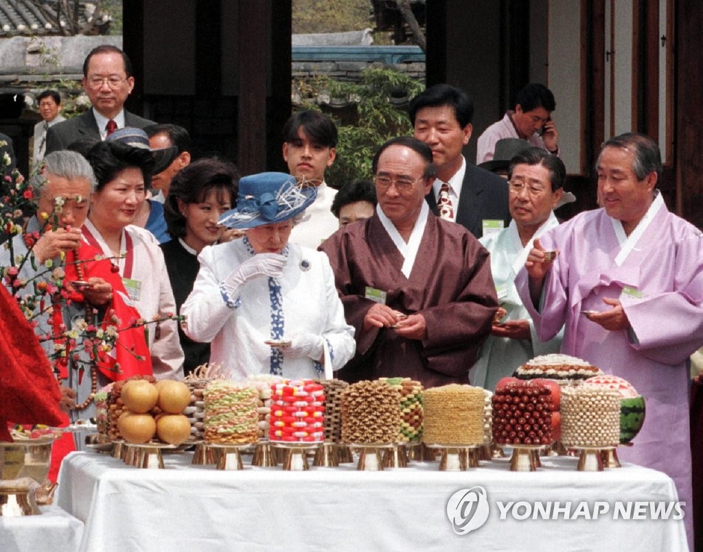 La foto de archivo, tomada en 1999, muestra a la reina Isabel II (3ª por la izda., con sombrero) celebrando su 73er. cumpleaños, durante su visita a la aldea Hahoe, en la ciudad de Andong, en el sureste de Corea del Sur.