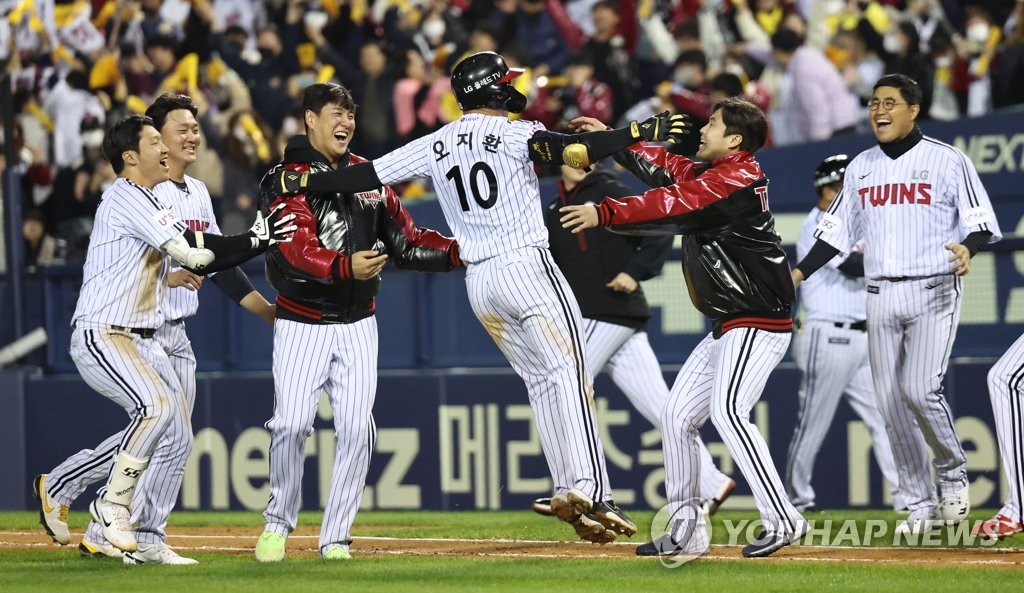 Oh Ji-hwan of the LG Twins (C) is mobbed by teammates after hitting a walk-off single against the KT Wiz during the bottom of the ninth inning of a Korea Baseball Organization regular season game at Jamsil Baseball Stadium in Seoul on Oct. 11, 2022. (Yonhap)
