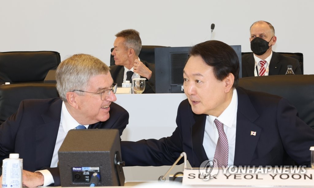 El presidente surcoreano, Yoon Suk-yeol (dcha.), habla con el presidente del Comité Olímpico Internacional, Thomas Bach, durante la 26ª Asamblea General de la Asociación de Comités Olímpicos Nacionales, celebrada, el 19 de octubre de 2022, en el Centro de Convenciones y Exhibiciones, en Seúl.