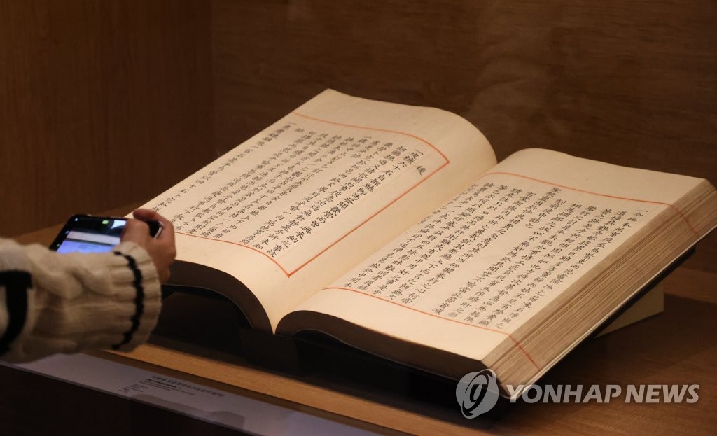 A participant looks at Uigwe, manuscripts for royal protocols during the Joseon Dynasty (1392-1910), during a media event for a special exhibition at the National Museum of Korea in central Seoul on Oct. 31, 2022, to commemorate the 10th anniversary of its return from France. The exhibition runs from Nov. 1 to March 19, 2023. (Yonhap)