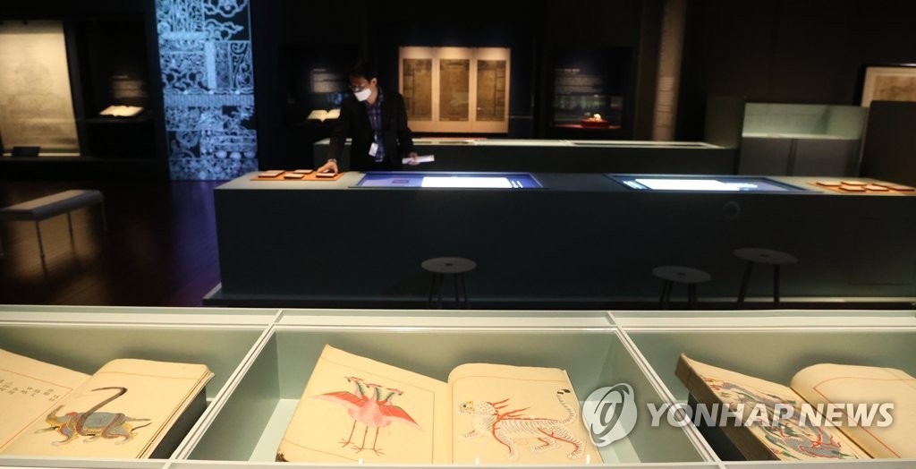Participants look at Uigwe, manuscripts for royal protocols during the Joseon Dynasty (1392-1910), during a media event for a special exhibition at the National Museum of Korea in central Seoul on Oct. 31, 2022, to commemorate the 10th anniversary of its return from France. The exhibition runs from Nov. 1 to March 19, 2023. (Yonhap)
