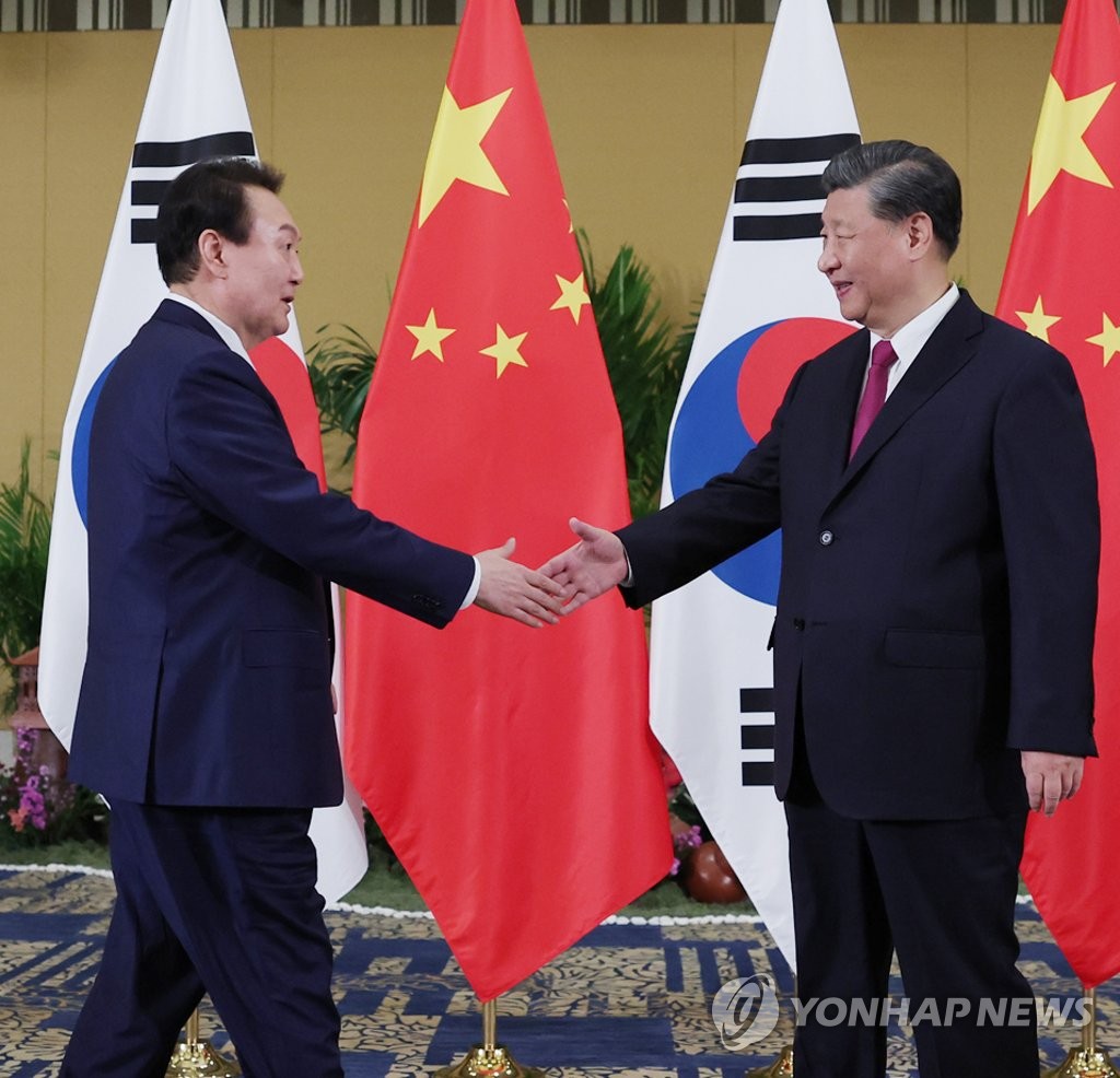 South Korean President Yoon Suk-yeol (L) shakes hands with his Chinese counterpart, Xi Jinping, during their bilateral talks at a hotel in Bali, Indonesia, on Nov. 15, 2022, on the sidelines of a Group of 20 summit. (Yonhap)