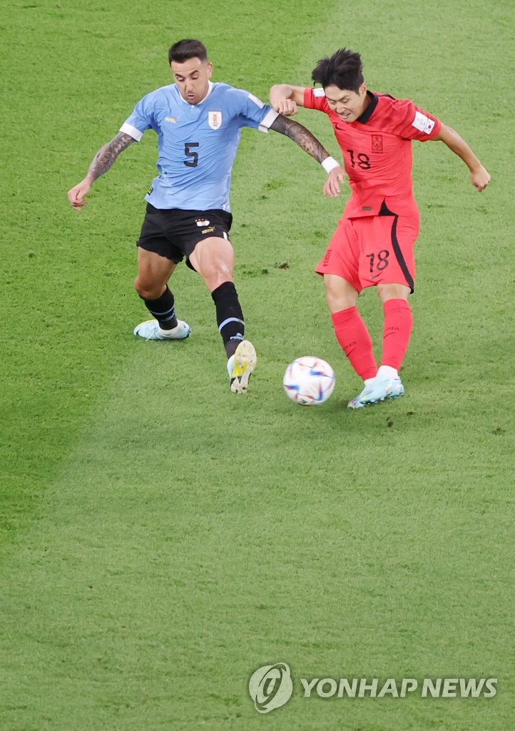 Lee Kang-in of South Korea (R) battles Matias Vecino of Uruguay for the ball during their Group H match at the FIFA World Cup at Education City Stadium in Al Rayyan, west of Doha, on Nov. 24, 2022. (Yonhap)