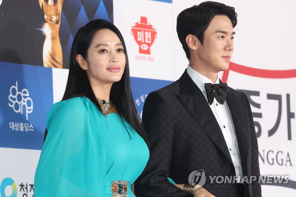 Actors Kim Hye-soo (L) and Yoo Yeon-seok, co-hosts of the 42nd Blue Dragon Awards, enter the red carpet of the ceremony held at KBS Hall in Seoul on Nov. 26, 2021. (Yonhap)