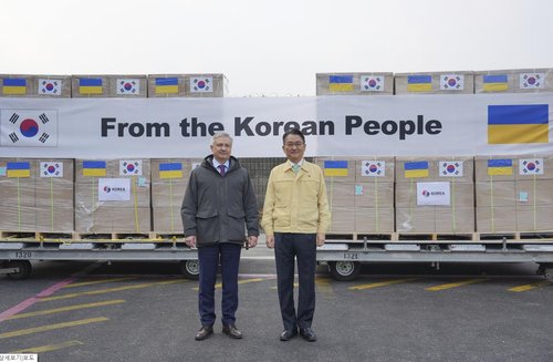 Park Yong-min (R), South Korean deputy foreign minister for multilateral and global affairs, and Ukrainian Ambassador to South Korea Dmytro Ponomarenko pose for photos in front of humanitarian aid items prepared to be flown to Ukraine at Incheon International Airport on Dec. 9, 2022. (PHOTO NOT FOR SALE) (Yonhap)