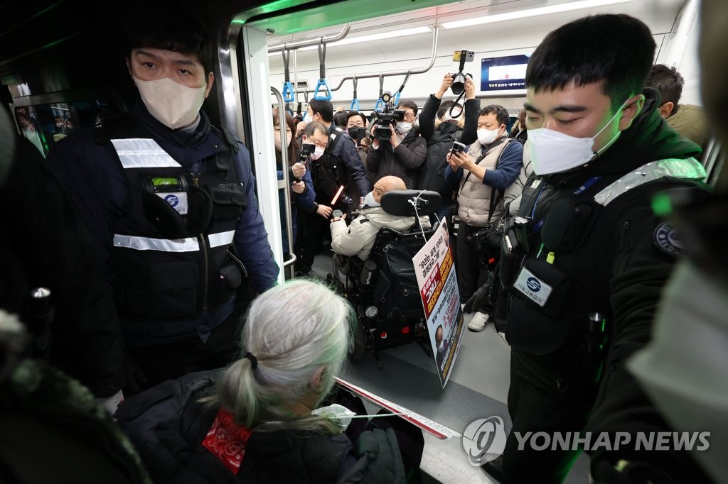 Members of the Solidarity Against Disability Discrimination board a subway train at Samgakji Station in Seoul on Dec. 13, 2022, as part of their demonstration demanding an increased government budget to protect the rights of people with disabilities. (Yonhap)