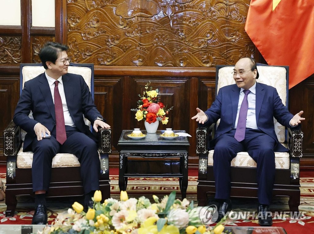 El director ejecutivo de la Agencia de Noticias Yonhap, Seong Ghi-hong (izda.), habla con el presidente vietnamita, Nguyen Xuan Phuc, el 14 de diciembre de 2022, en el palacio presidencial, en Hanói.