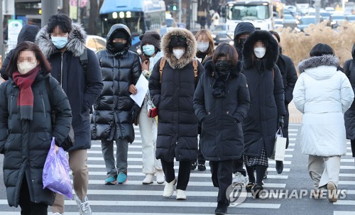 ソウル中心部の光化門広場を防寒着に身を包んだ人々が行き交っている＝２５日、ソウル（聯合ニュース）