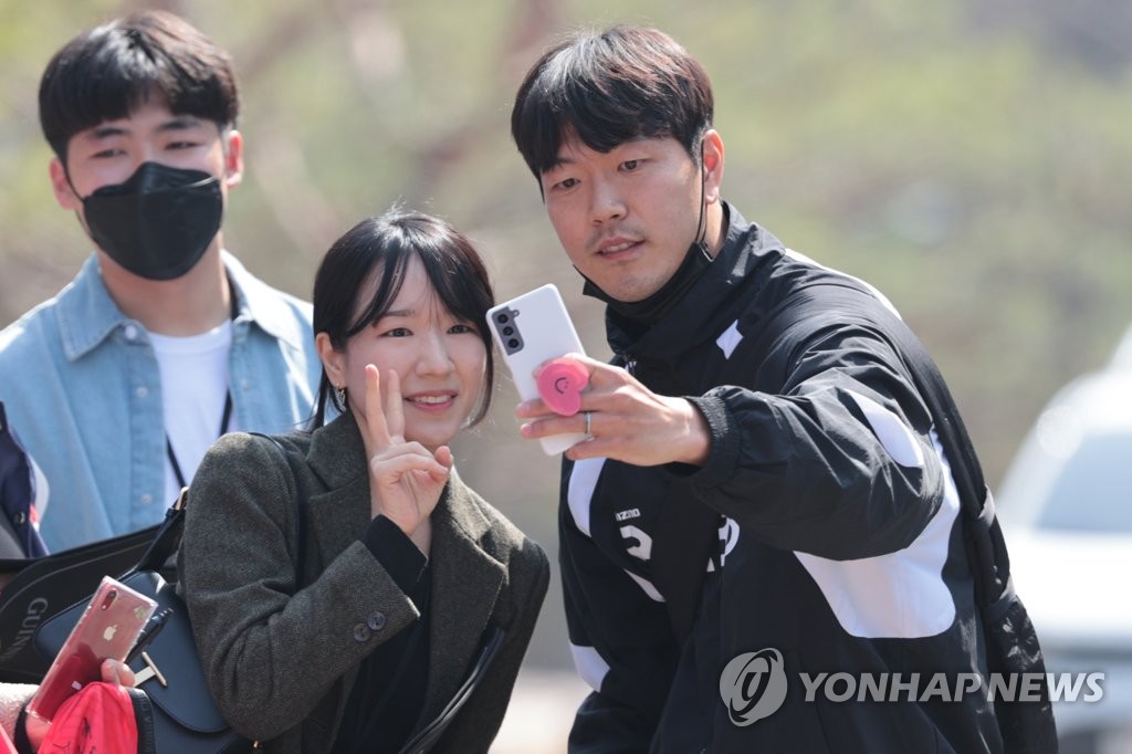 South Korean center back Kim Young-gwon (R) takes a selfie with a fan before reporting to the National Football Center in Paju, some 30 kilometers northwest of Seoul, for training camp on March 20, 2023. (Yonhap)