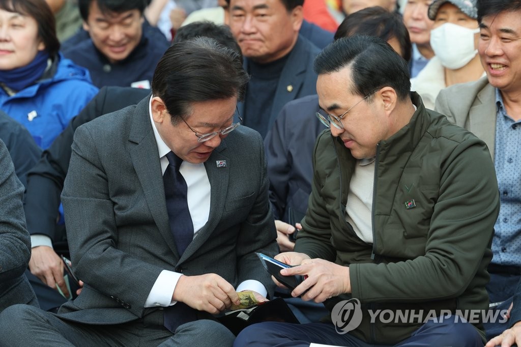 헌금 위해 돈 꺼내는 이재명-박홍근