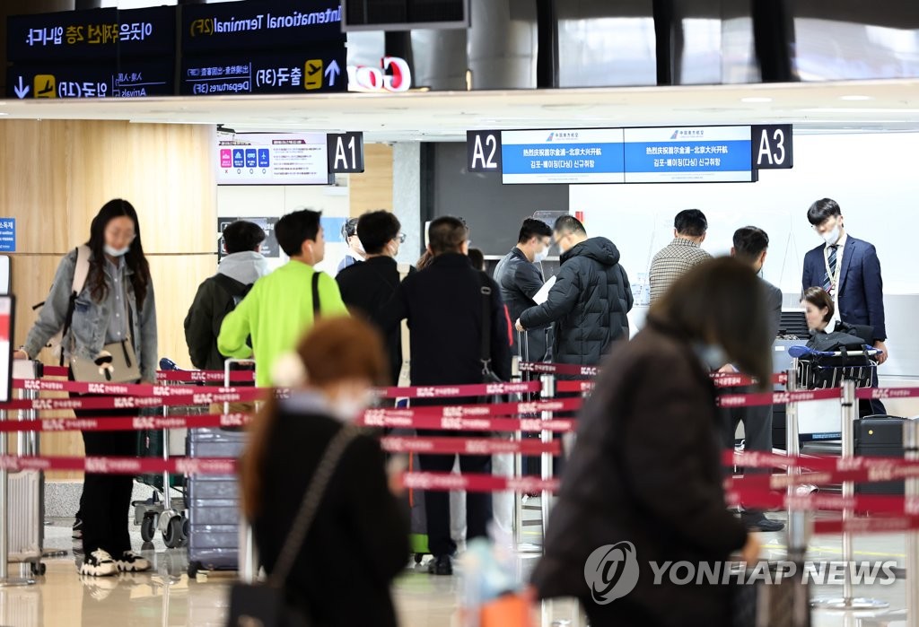 People line up at a China Southern Airlines check-in desk at Gimpo International Airport, just west of Seoul, on March 26, 2023. (Yonhap)