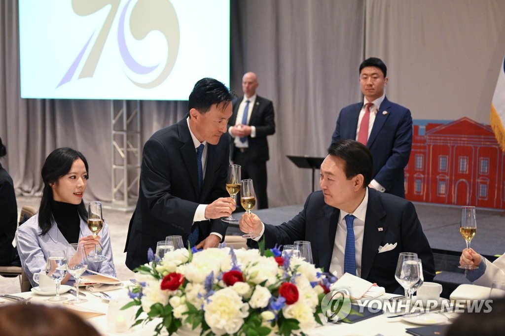 President Yoon Suk Yeol (R) clinks glasses with an attendee during a dinner with Korean Americans at a hotel in Washington on April 24, 2023. (Yonhap)